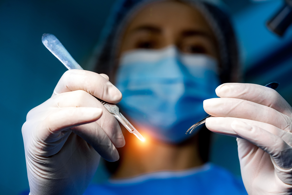 Veterinarian in gloves performing a laser procedure in a clinical exam room