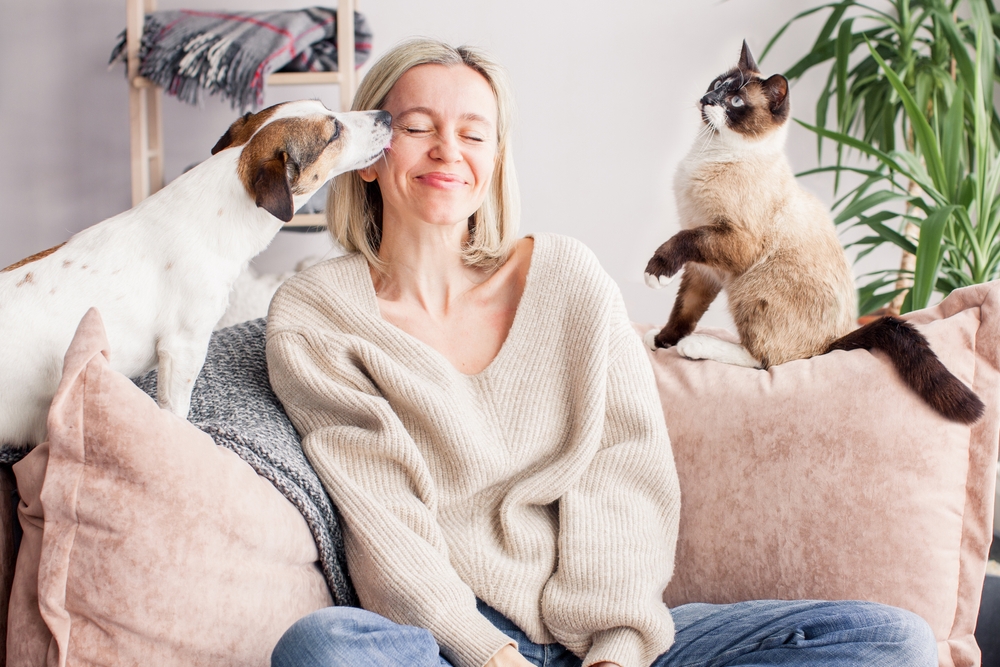 Woman smiling with eyes closed while enjoying time with her pet